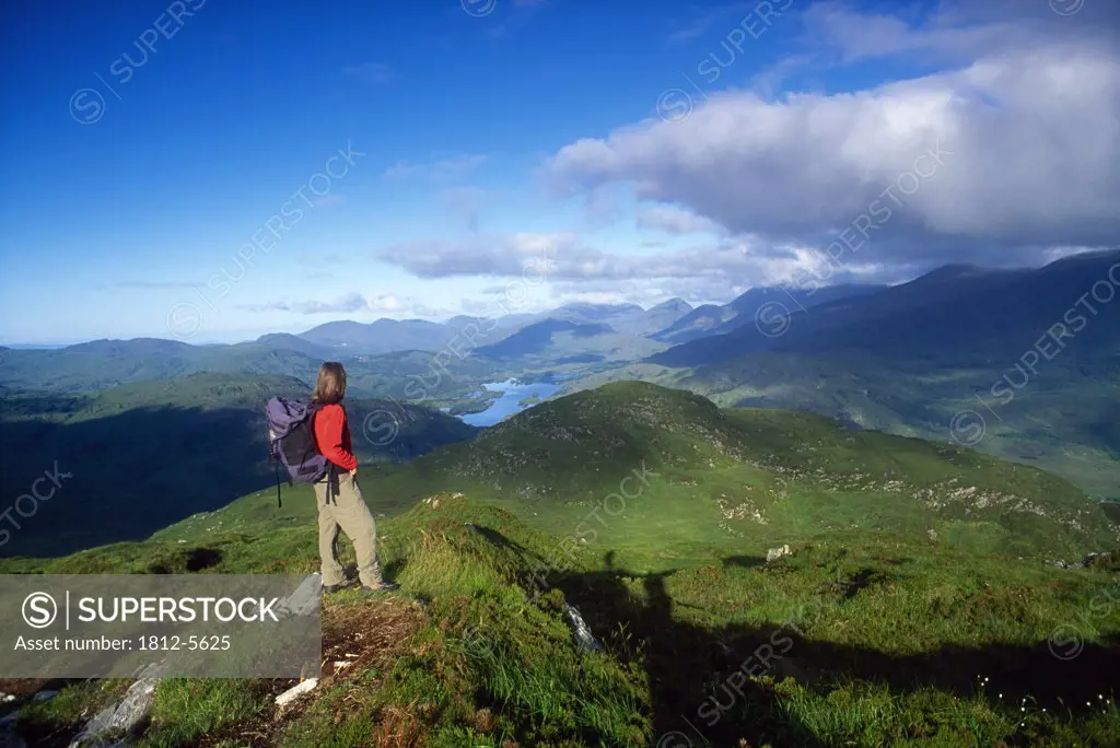 Macgillycuddy's Reeks from Torc Mountain, Killarney National Park, County Kerry, Ireland; Hiker on mountain top