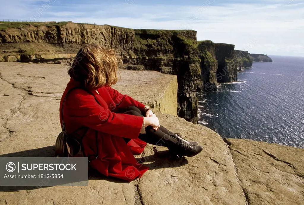 Cliffs of Moher, County Clare, Ireland; Woman enjoying the view from a cliff