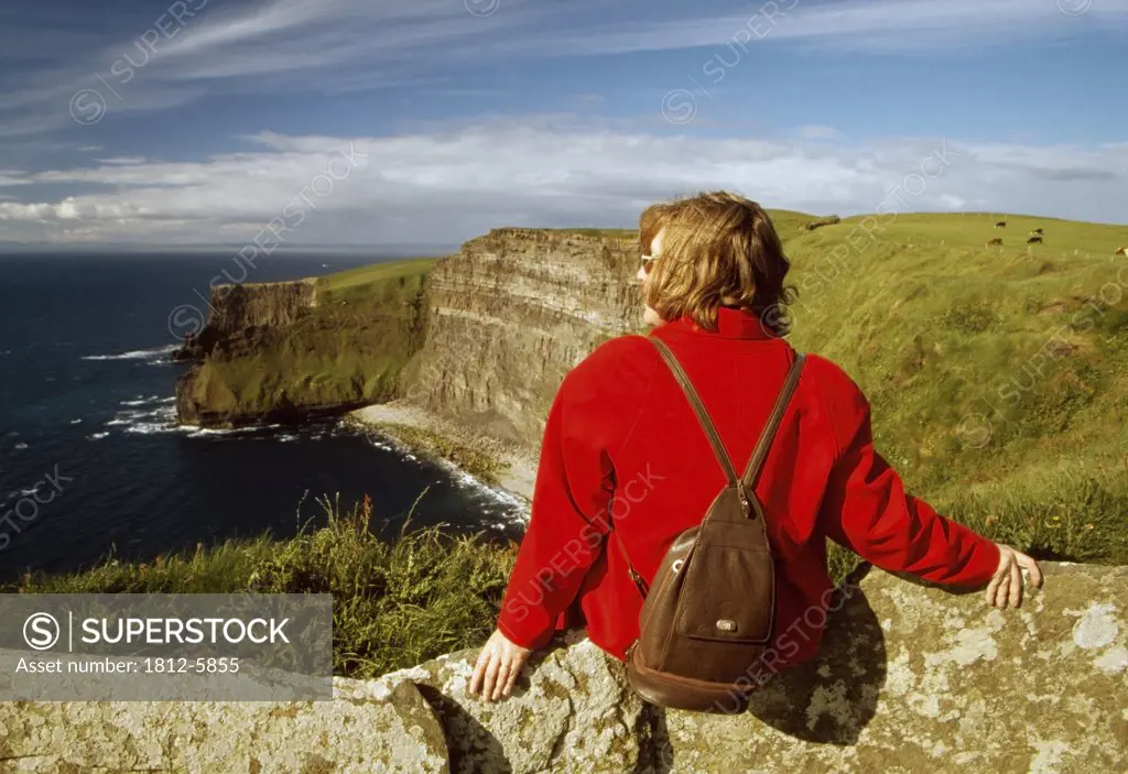 Cliffs of Moher, County Clare, Ireland; Woman enjoying the view from a cliff