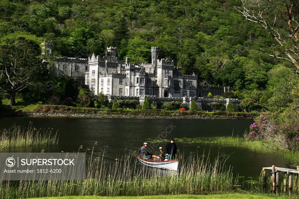 Kylemore Abbey, Connemara, County Galway, Ireland; People in boat in front of historical abbey