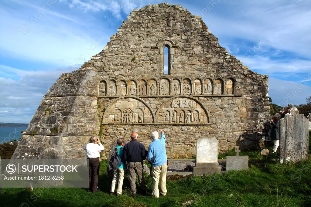 Ardmore Cathedral, County Waterford, Ireland; Tourists examining carvings on ruins