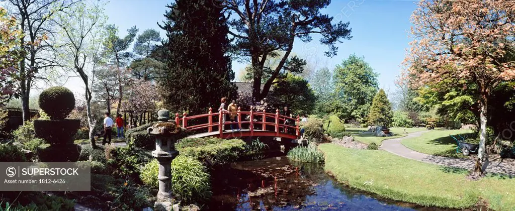 Tully Japanese Gardens, Tully, Co Kildare, Ireland, People walking over a bridge in a Japanese garden