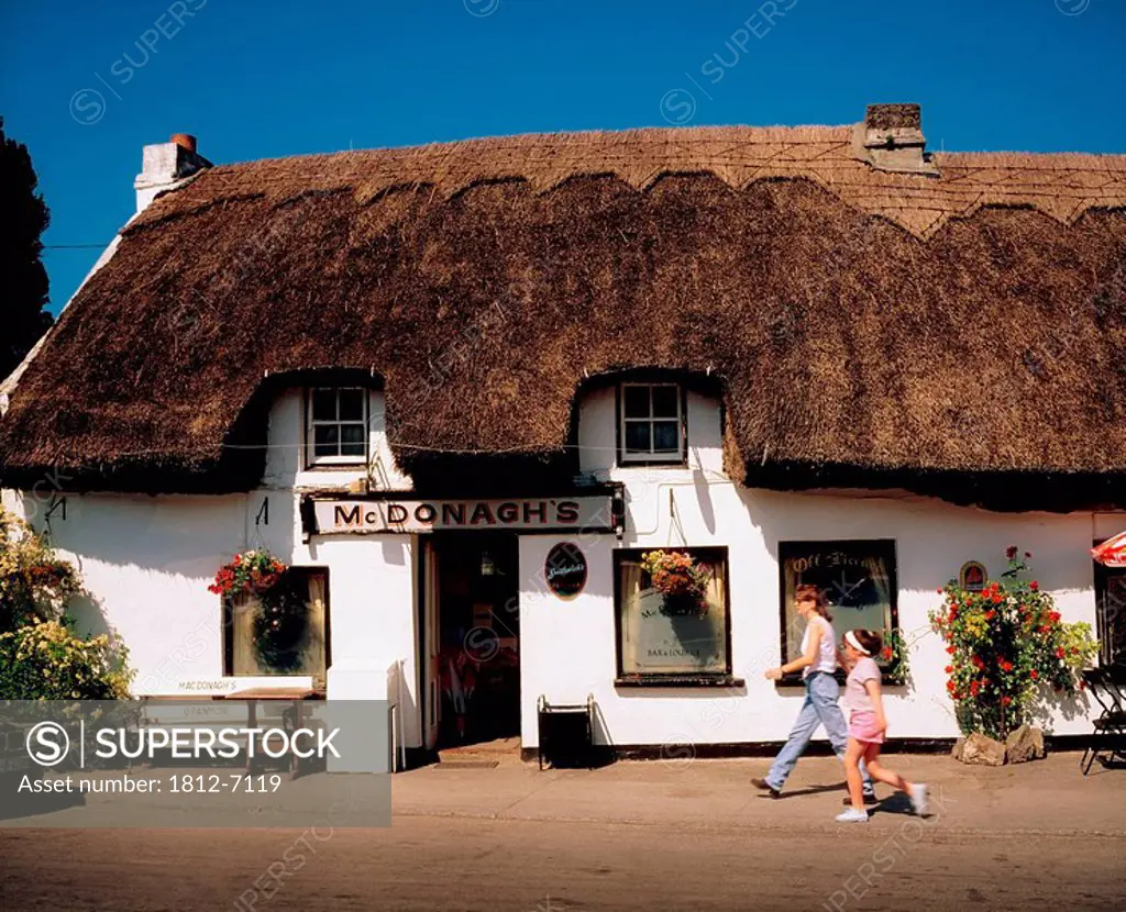 McDonagh´s Thatched Bar, Oranmore, Co Galway, Ireland, Woman and girl walking outside of a bar