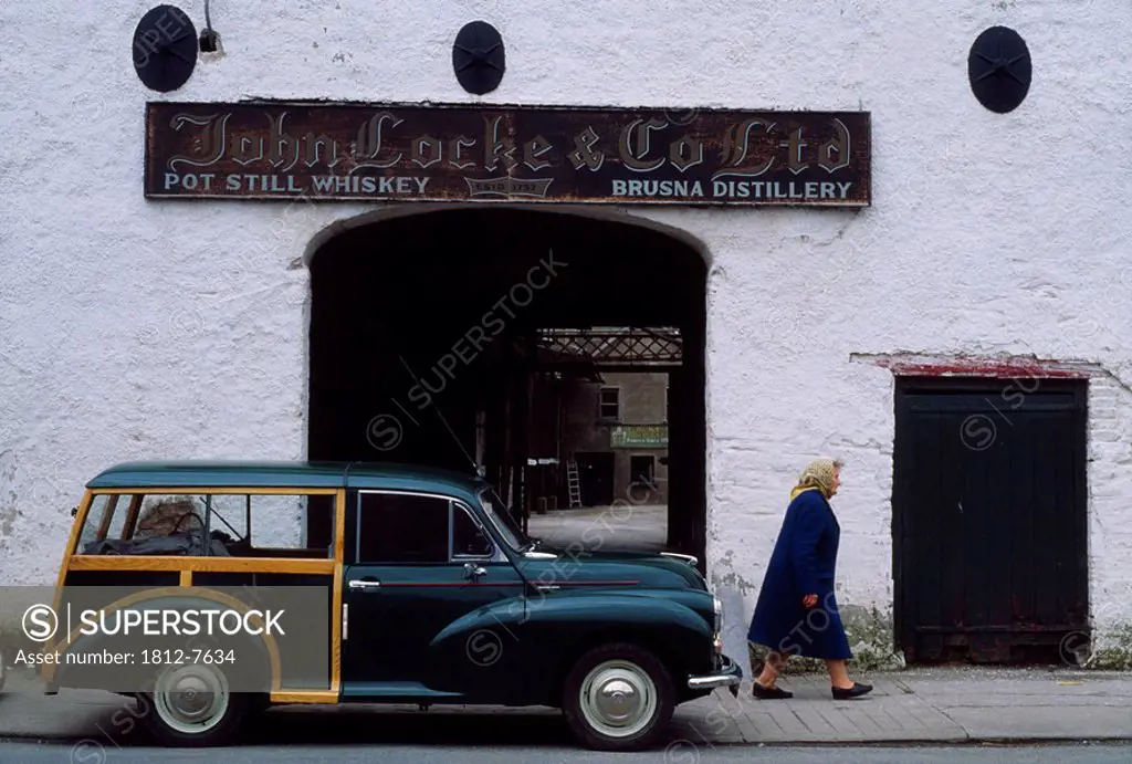 Morris Minor, Locke´s Distillery, Kilbeggan, Co Westmeath, Ireland, Woman walking by a vintage car and 18th Century distillery