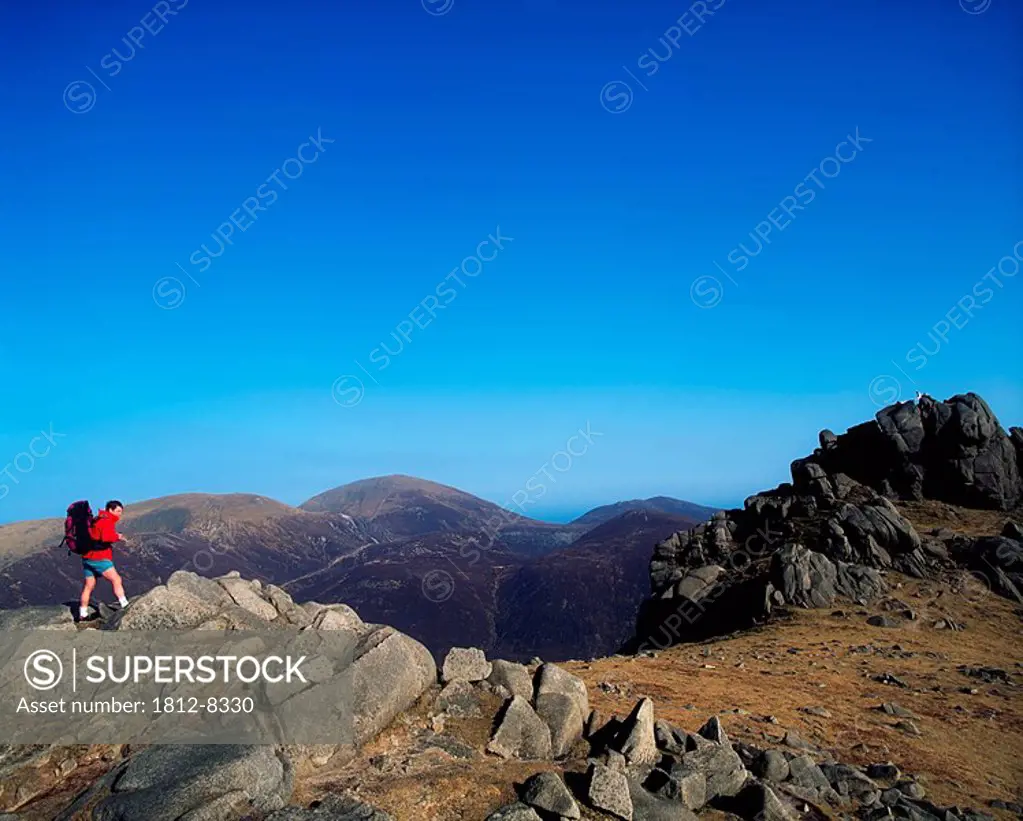 Mourne Mountains, Co Down, Ireland, Hiker on Slieve Bearnagh with a view of Slieve Donard