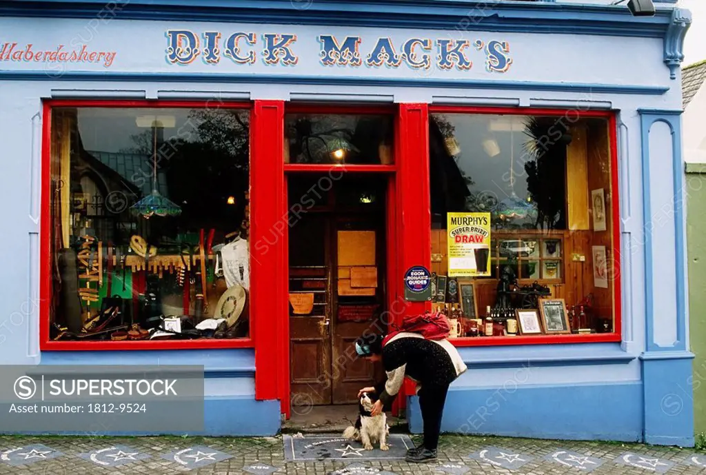 Dick Mack´s Pub, Dingle, Co Kerry, Ireland, Woman and dog outside of a pub and shoeshine shop