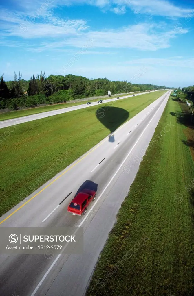 Car driving, Silhouette of a hot air balloon over a highway