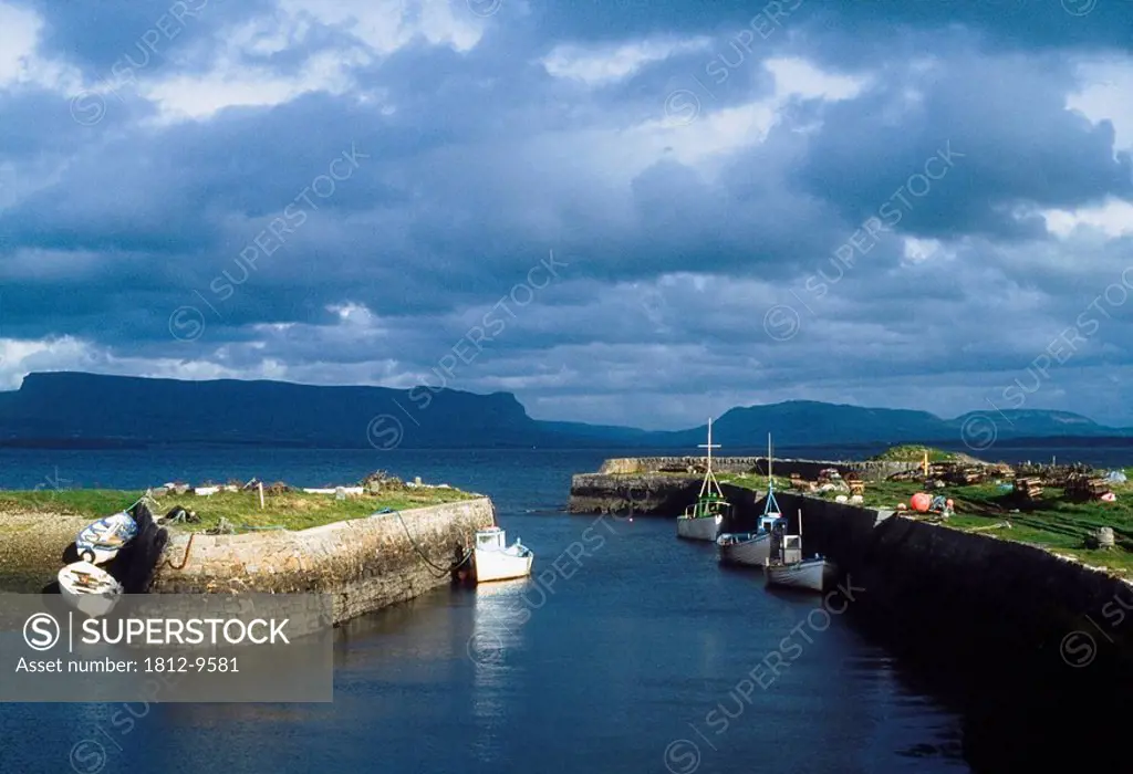 Ben Bulben, Co Sligo, Ireland, Docked boats across from a rock formation