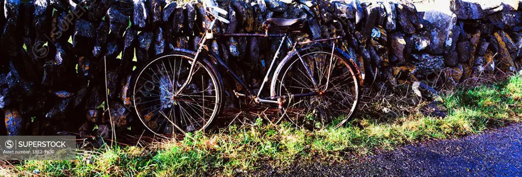 The Burren, County Clare, Ireland, Bicycle leaning against stone wall