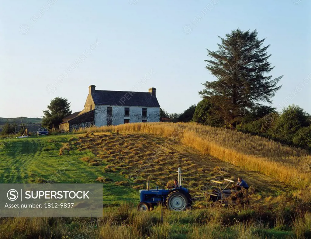 County Cork, Ireland, Farmer on tractor harvesting field