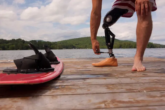 Athlete adjusting his artificial leg on a dock