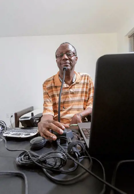 Man with Guillain-Barre Syndrome using his technical equipment at home office