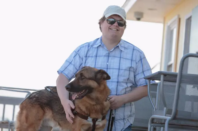 Blind man with his service dog at an outdoor cafe