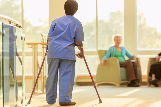 Nurse with Cerebral Palsy walking down the hallway of a clinic with her canes