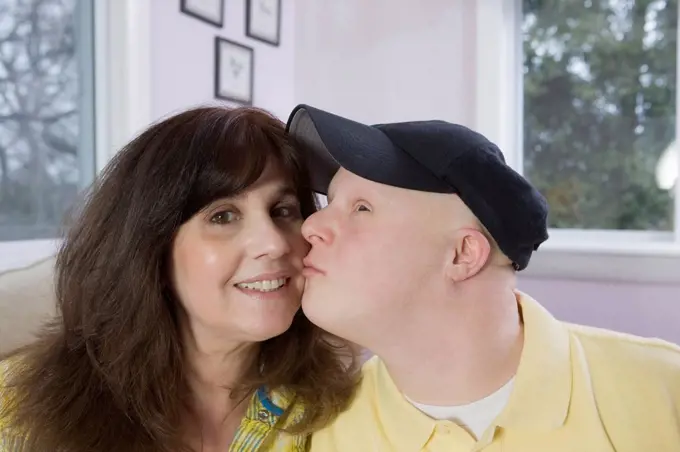Man with Down Syndrome kissing his mother