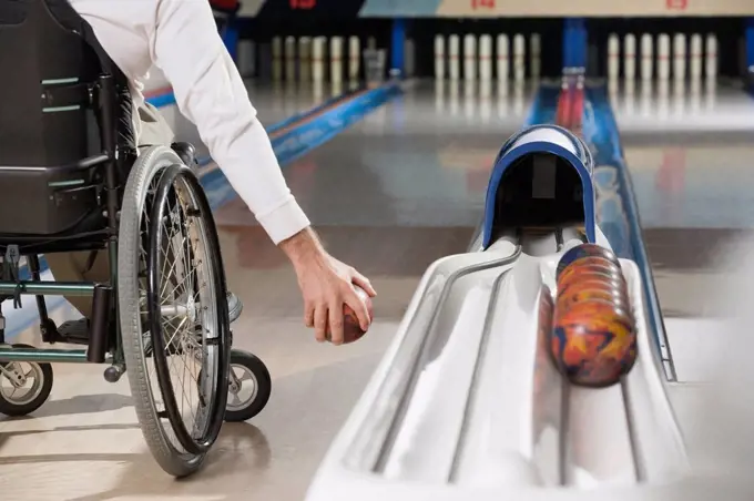 Low section view of a man with a Spinal Cord Injury playing ten pin bowling