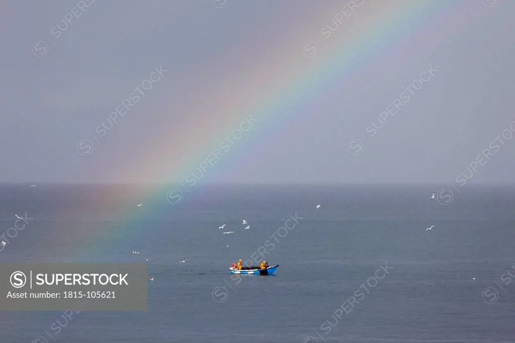 Ireland, Leinster, County Fingal, View of boat in sea with rainbow