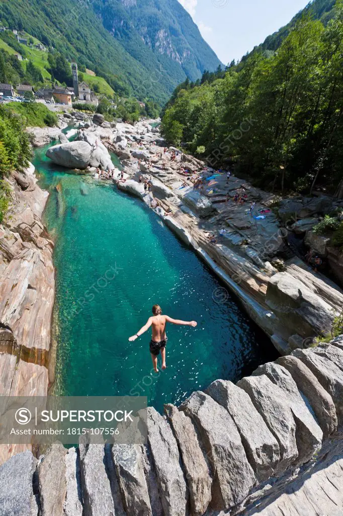 Switzerland, Ticino, Boy jumping into river