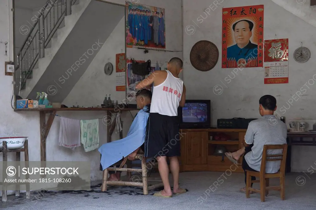 China, Yangshuo, Hairdresser cutting hair of customer in salon