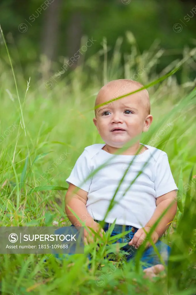 USA, Texas, Baby boy sitting on grass and crying