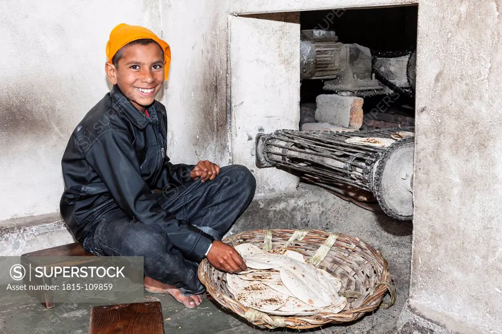 India, Punjb, Amritsar, Boy preparing naan in kitchen