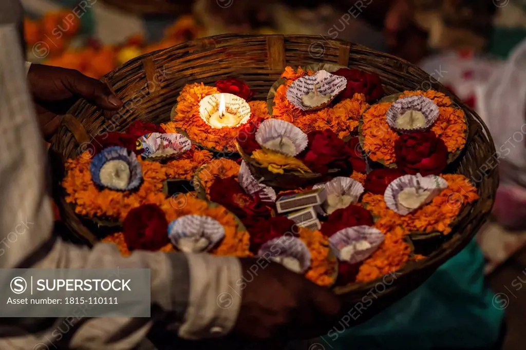 India, Uttar Pradesh,Leaf bowls with flowers and oil lamp for Aarti at Ganges river