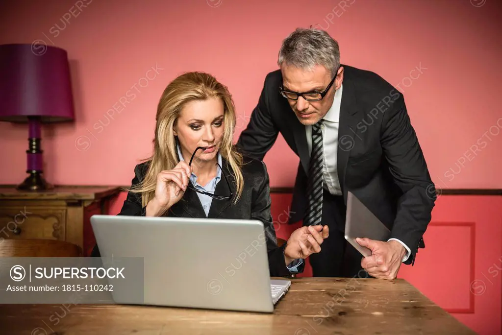 Germany, Stuttgart, Businessman and woman working on laptop