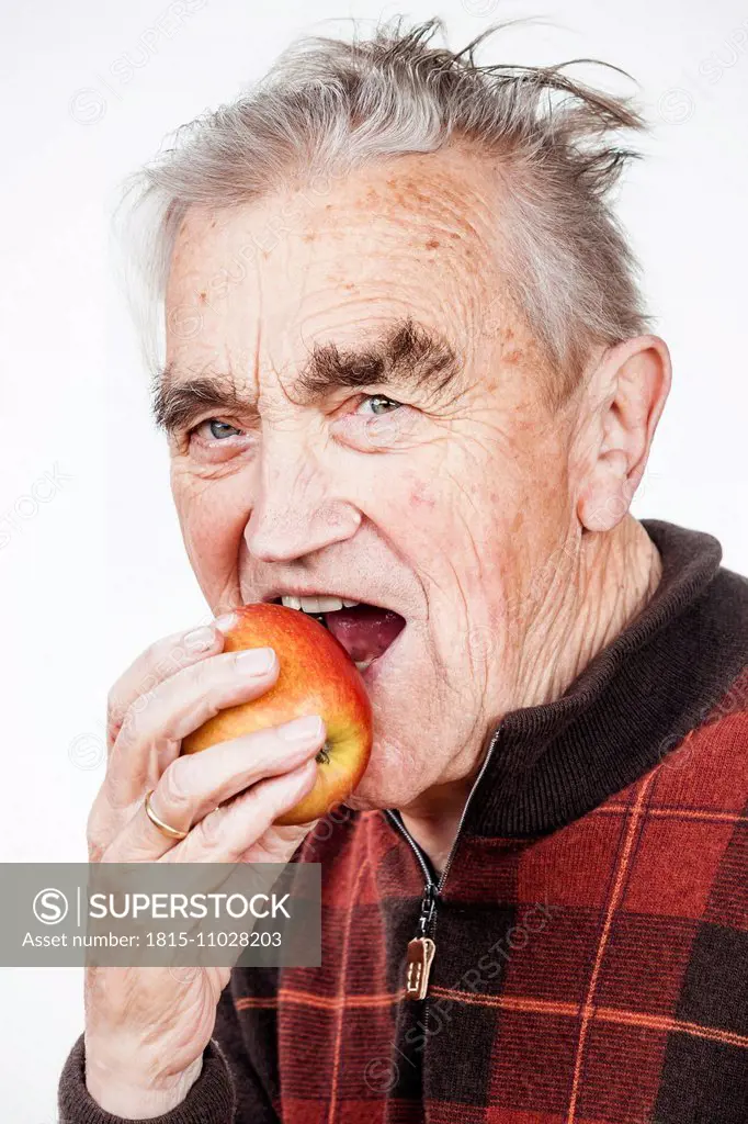 Portrait of senior man eating apple
