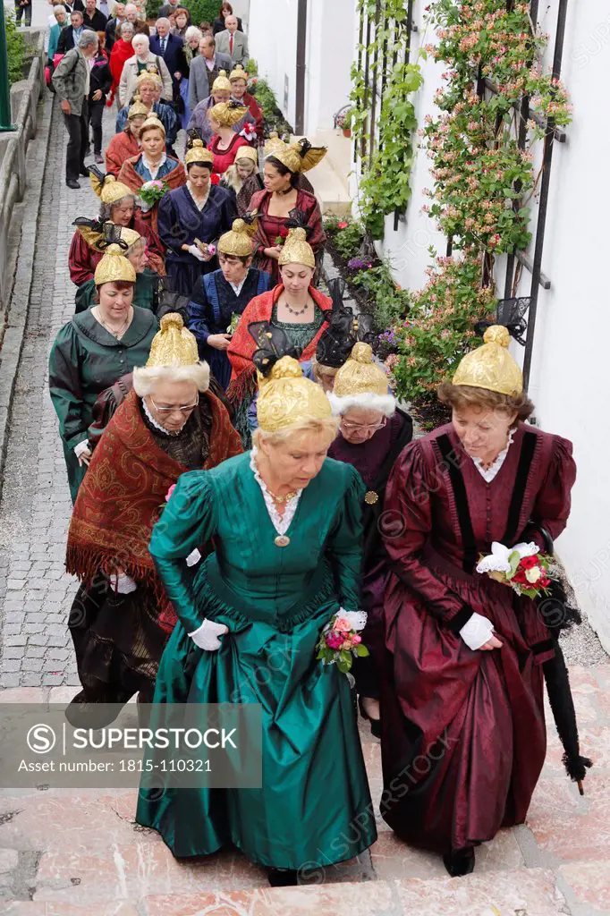 Austria, Men and women in traditional costume walking in parade