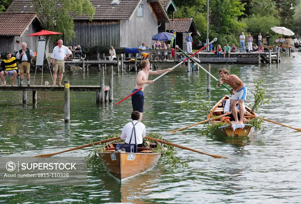 Germany, Bavaria, People jousting in boat at Lake Starnberg