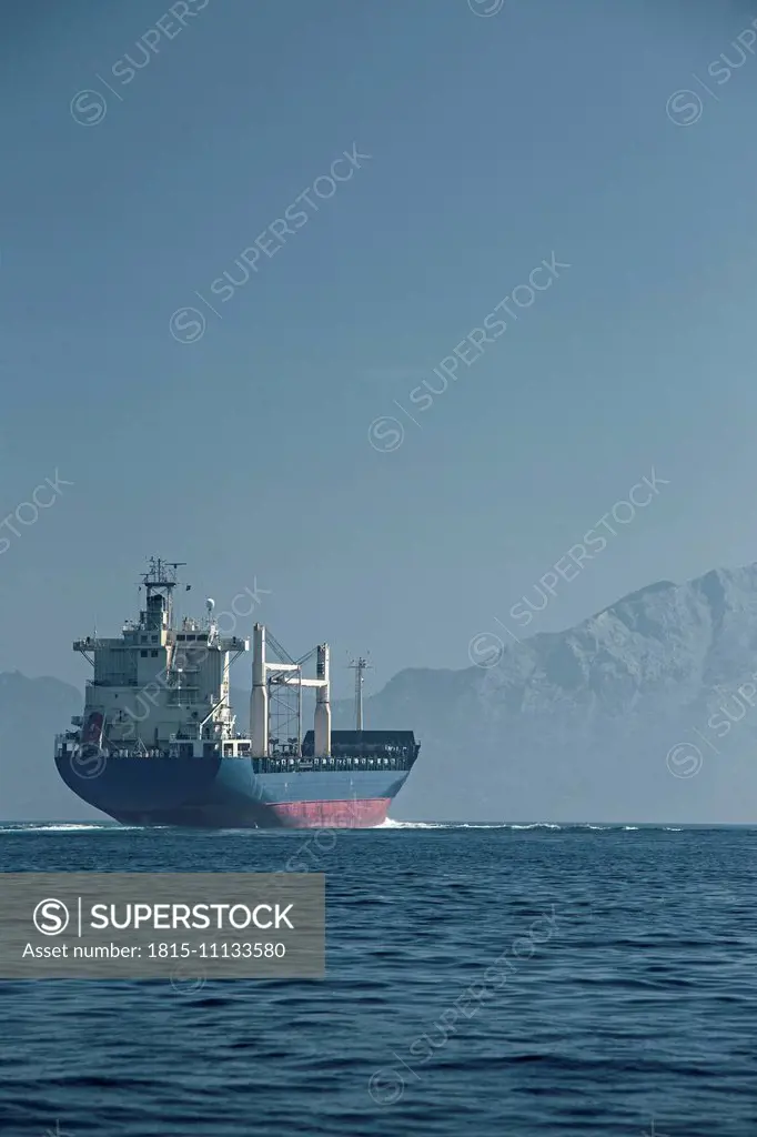 Africa, Morocco, Tanger, Cargo ship in front of Jebel Musa, Strait of Gibraltar
