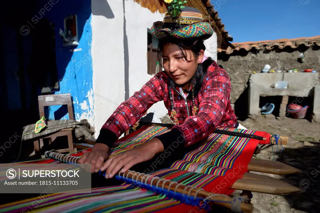 Peru, Quispillacts, Young woman weaving traditional cloth