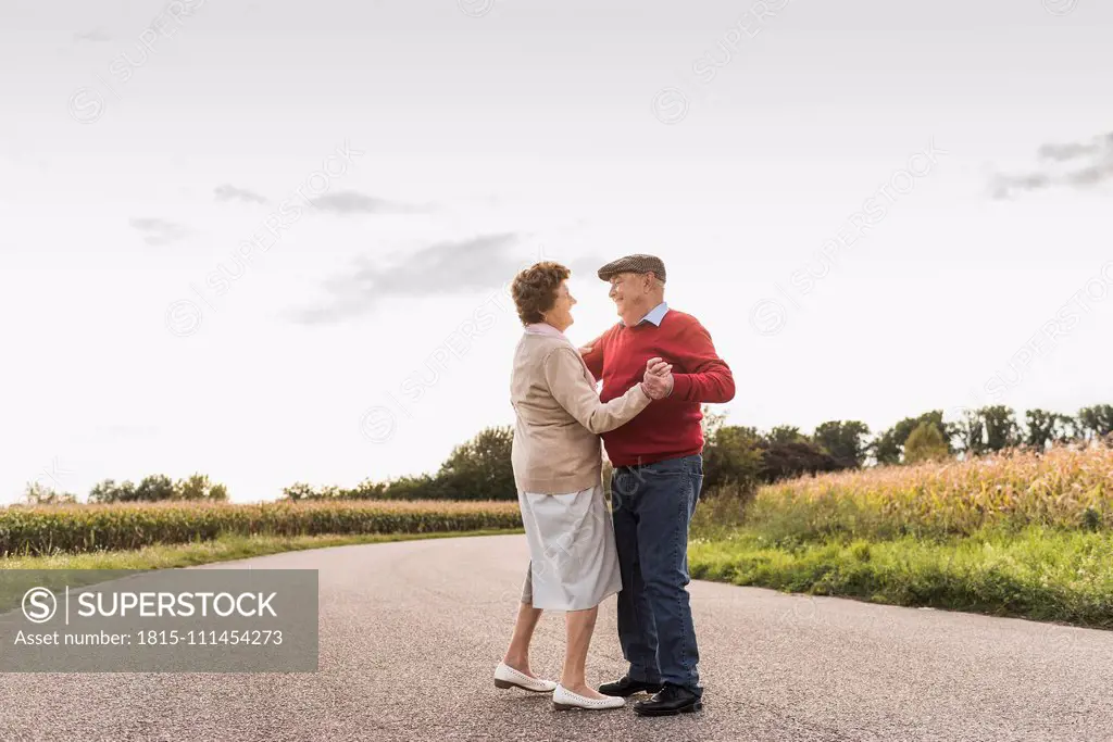 Senior couple dancing on country road