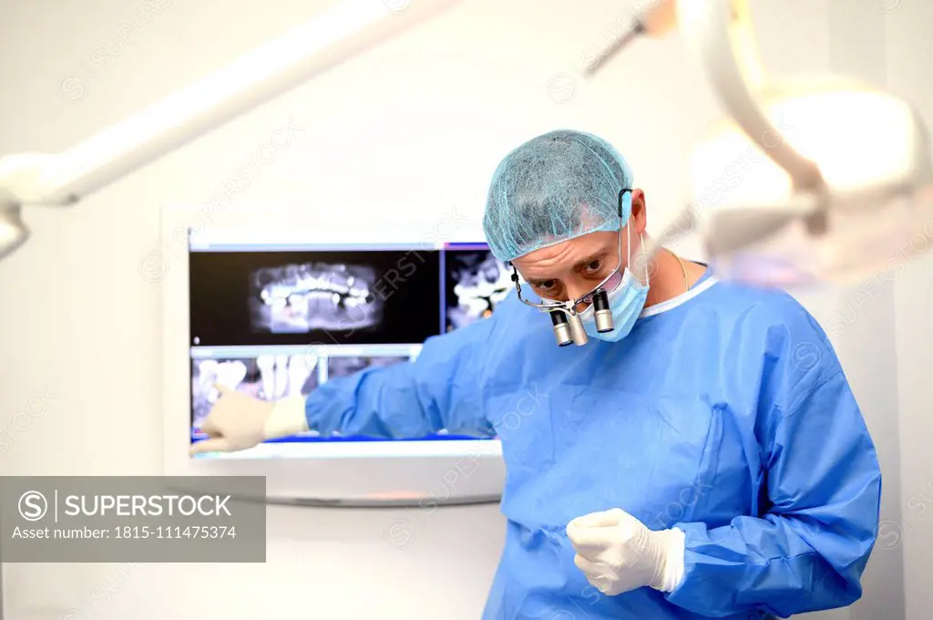 Dentist surgeon showing patient implant radiography