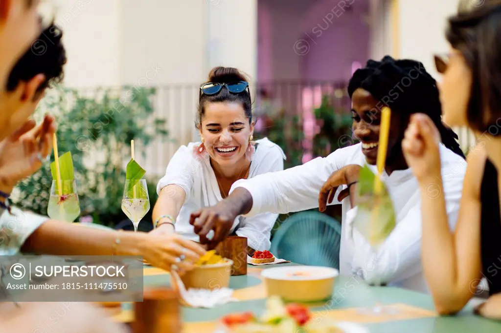 Happy multi-ethnic friends having fun during a party, eating together