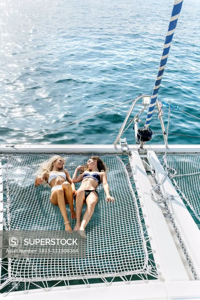 Two beautiful women enjoying a summer day on a sailboat