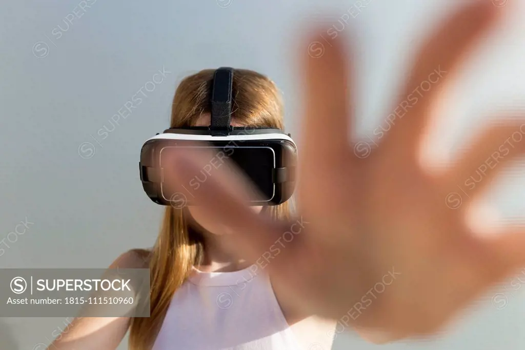 Young woman using Vr googles, reaching with her hand