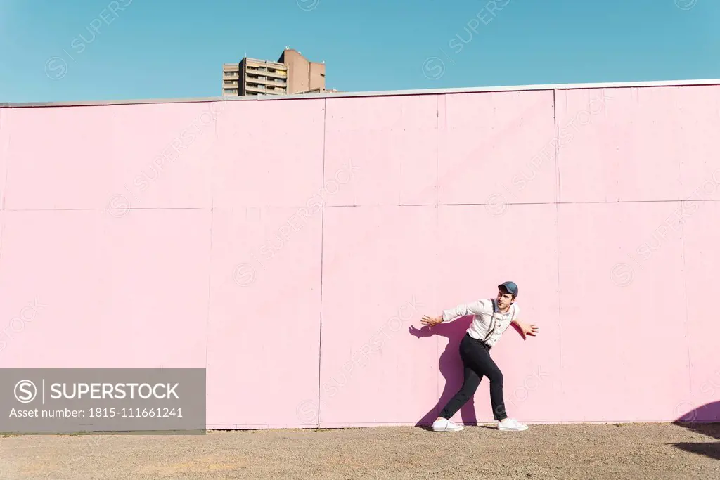 Young man in front of pink construction barrier, trying to escape