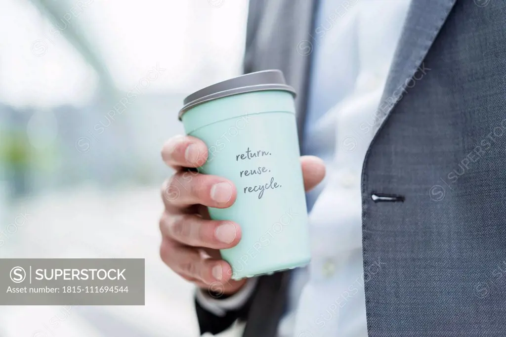 Close-up of businessman holding recycable takeaway coffee cup