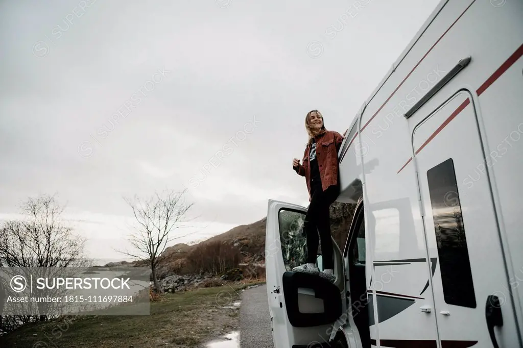 UK, Scotland, Highland, happy young woman at a camper van