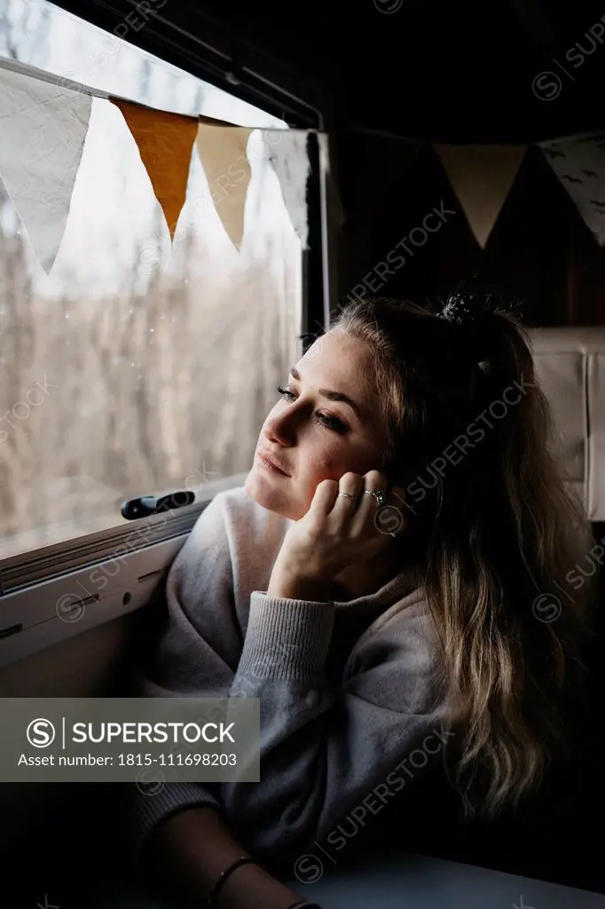 Pensive young woman looking out of car window