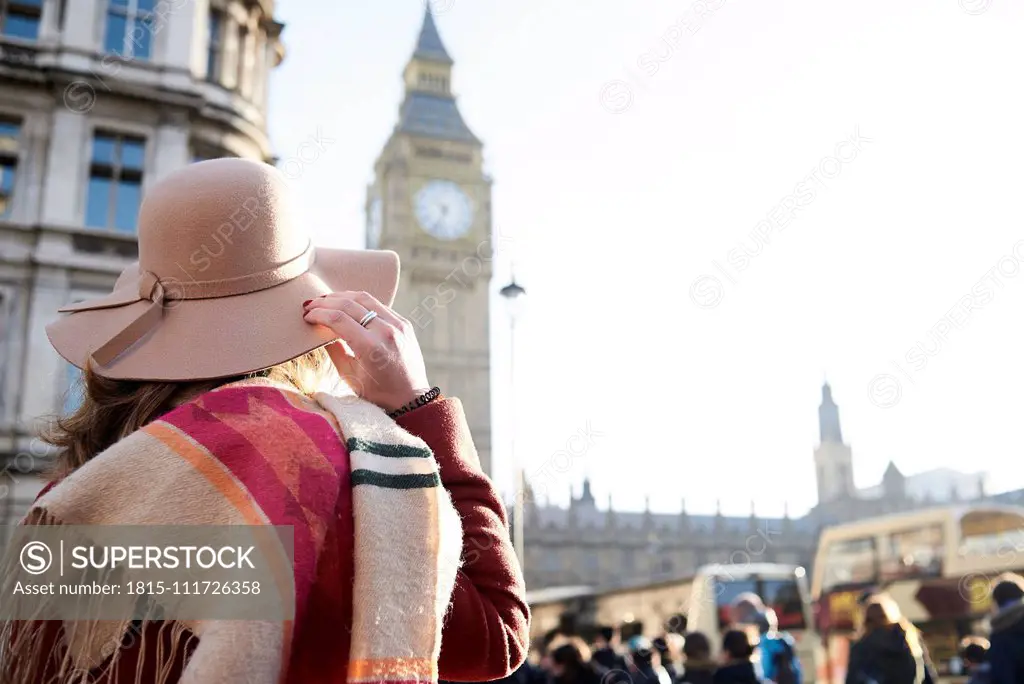UK, London, rear view of woman wearing a floppy hat looking at Big Ben