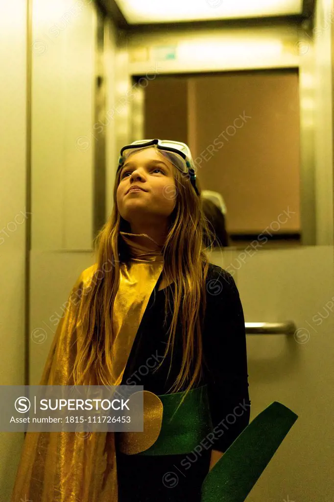 Girl in super heroine costume in elevator looking up