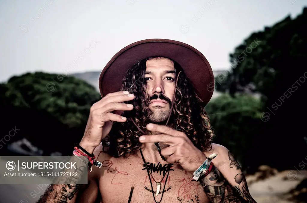 Young man with hat, tattoos and mustache