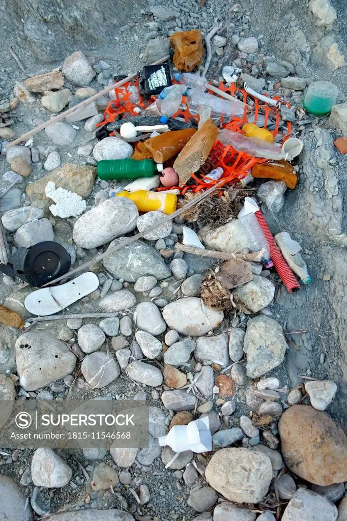 Spain, Baleares, Ibiza, washed up plastic waste on stony beach