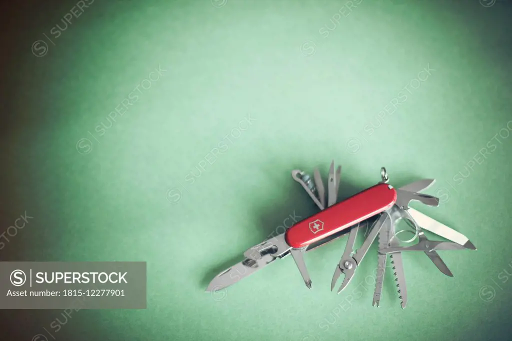 Swiss army knife on green background