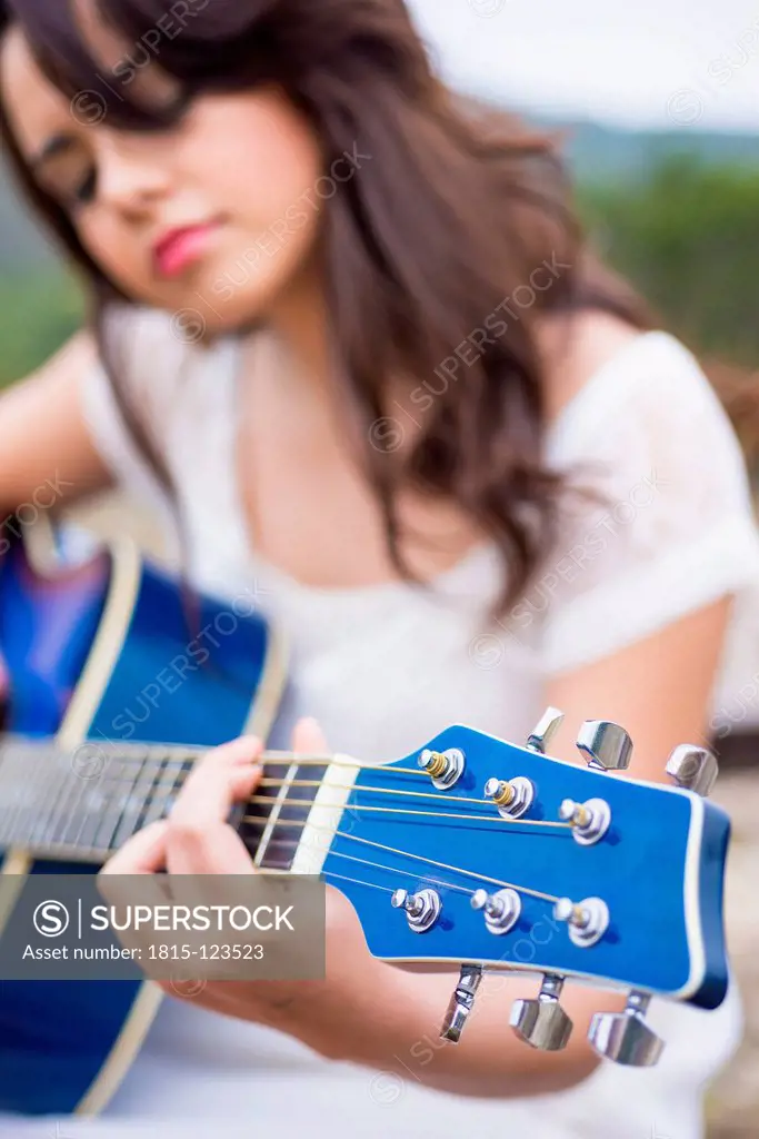 USA, Texas, Teenage girl playing guitar