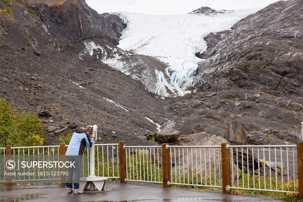USA, Alaska, Tourist looking through binocular at Worthington Glacier
