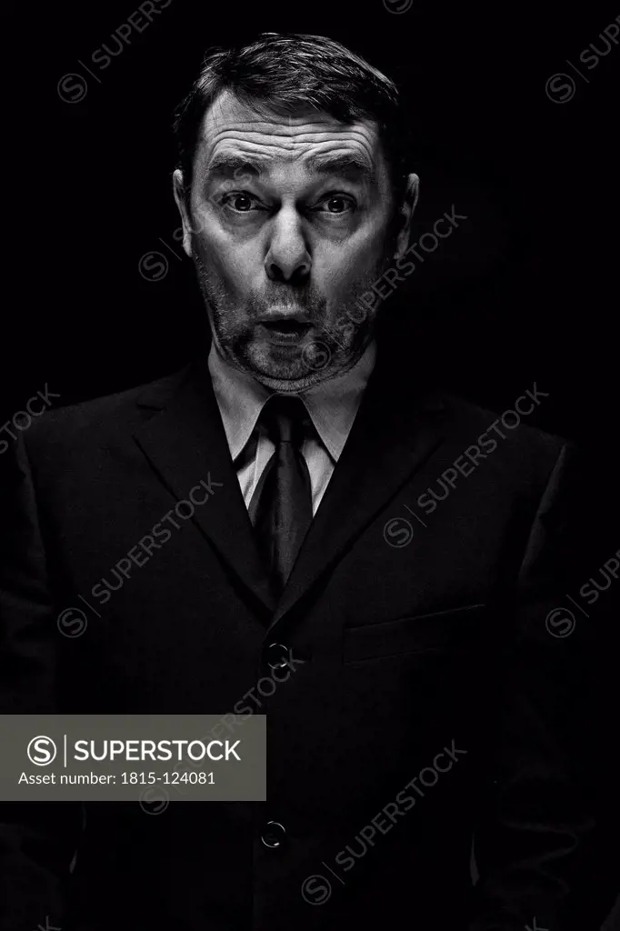 Surprised mature man against black background