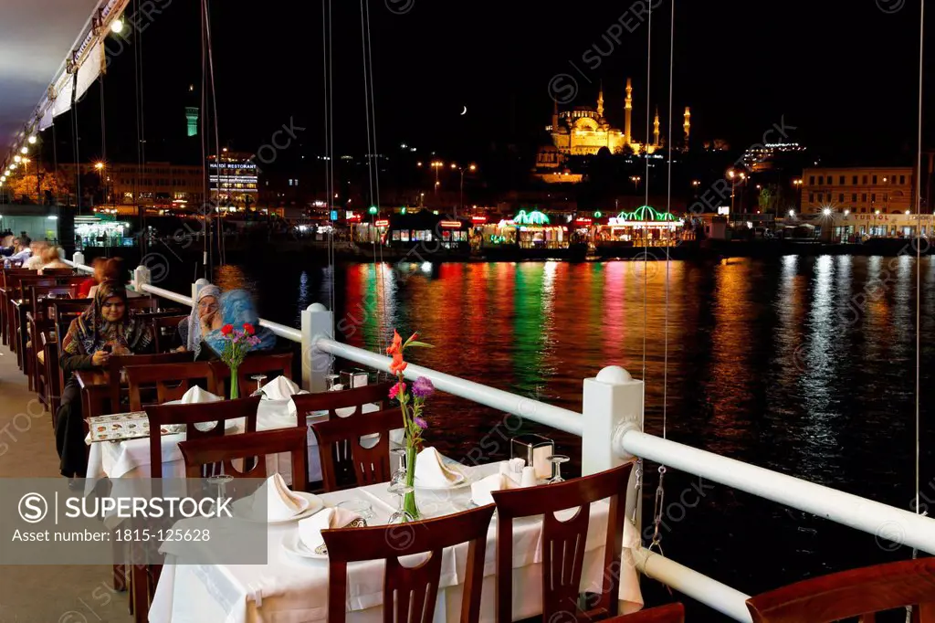 Europe, Turkey, Istanbul, Restaurants on Galata bridge and Suleymaniye Mosque in background